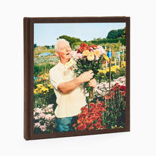 Load image into Gallery viewer, Front cover of allotments photography book by Andrew Buurman with man smelling bunch of flowers