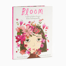 Load image into Gallery viewer, Hardback book cover of 'Bloom: A Story of Fashion Designer Elsa Schiaparelli' featuring an illustrated portrait of Schiaparelli with flowers and the title text.