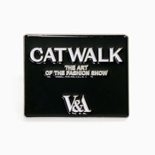 Load image into Gallery viewer, Close-up of Catwalk enamel pin inspired by fashion show exhibition at V&A Dundee