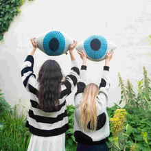 Load image into Gallery viewer, two models holding blue eye cushions.