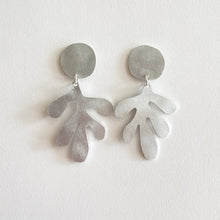 Load image into Gallery viewer, A pair of brushed aluminium statement drop earrings with sterling silver hoops, crafted in a leaf-like shape, displayed against a white background.