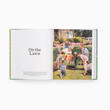 Load image into Gallery viewer, Open 'Garden Futures' book showing a photo of children playing on a lawn with text 'On the Lawn'.