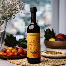 Load image into Gallery viewer, Bottle of premium olive oil by Olive Odyssey, Marda Palestine extra virgin olive oil bottle size 750ml sitting on a table with fruits and a pie.