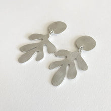Load image into Gallery viewer, Pair of silver leaf-shaped statement drop earrings on a white background