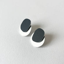 Load image into Gallery viewer, Pair of silver and black stud earrings with black oval design on a light grey background