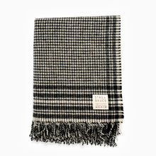 Load image into Gallery viewer, A black and white checkered wool blanket with fringes, displaying the Stag and Bruce brand tag.