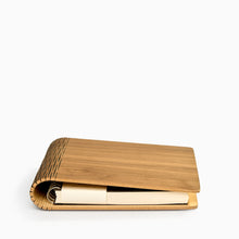 Load image into Gallery viewer, Close-up of refillable walnut notebook showing flexible laser-cut wooden hinge and maple inner detail