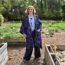 Load image into Gallery viewer, gardening robe on female model in garden purple blue irregular sleep pattern v&amp;a dundee 
