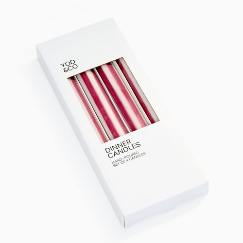 A set of four aubergine and white striped candles in a cardboard box packaging with the brand name 'yod & co' displayed.
