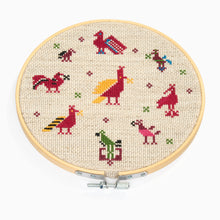 Load image into Gallery viewer, Embroidery hoop with colorful animal designs on a beige background
