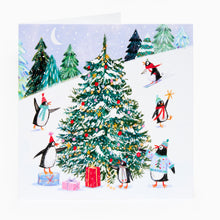 Load image into Gallery viewer, Illustration of penguins around a Christmas tree with presents in a snowy landscape.
