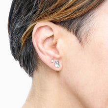 Load image into Gallery viewer, A set of  sterling silver stud earrings on models ear

