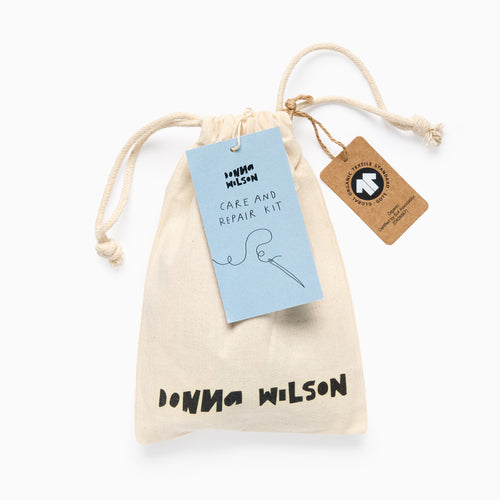 Donna Wilson care and repair kit with drawstring bag and tags on a white background