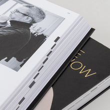 Load image into Gallery viewer, Open book Catwalk the Art Of The Fashion Show Exhibition Book with a black and white photo on one page and a black cover with gold text on the other, on a light gray surface. by Vitra Design Museum &amp; V&amp;A Dundee

