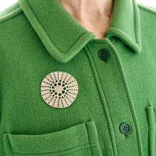 Load image into Gallery viewer, Flax Cell brooch by Tom Pigeon worn on green coat lapel
