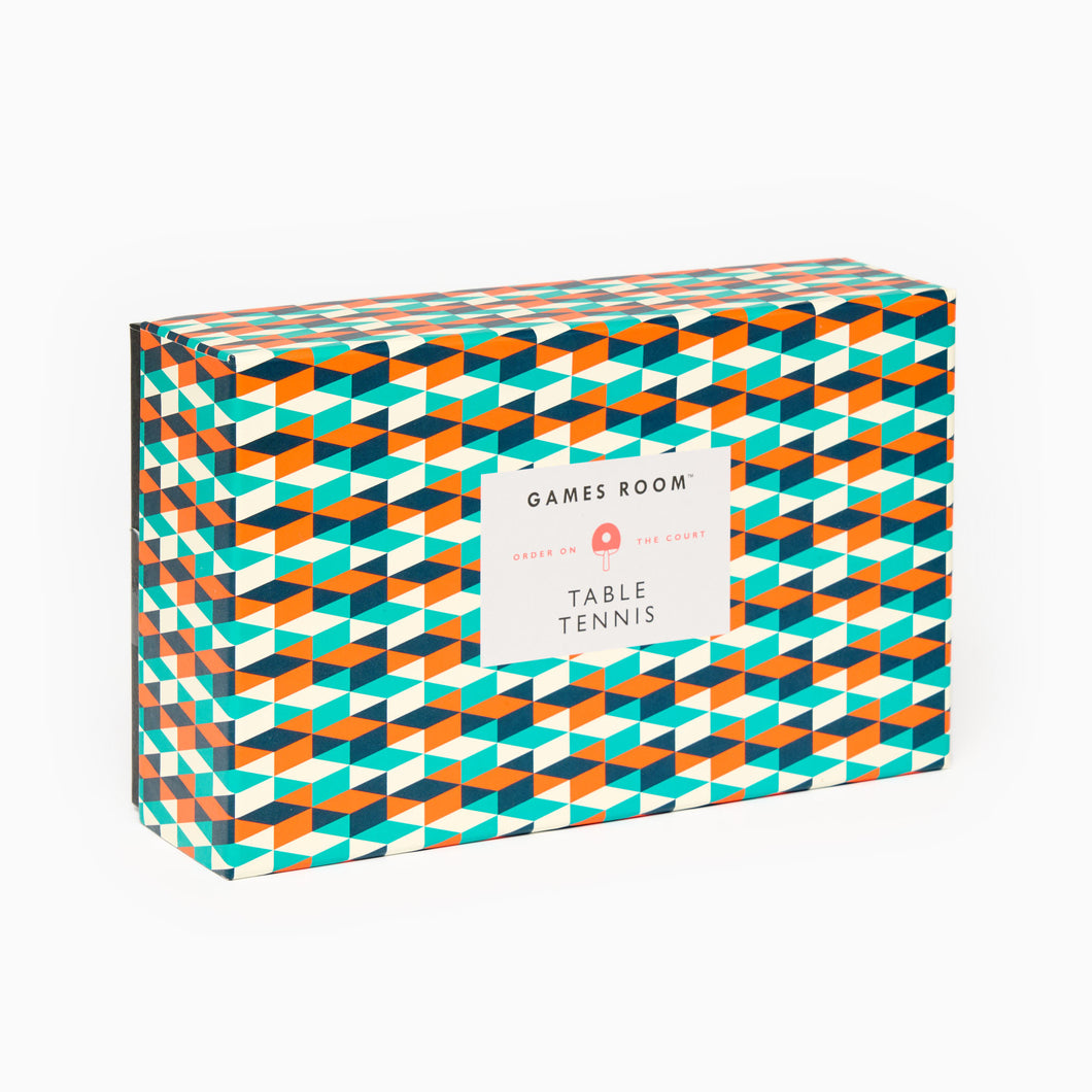 A boxed Games Room table tennis set with orange and teal geometric pattern on the packaging, including two bats, three balls, and an adjustable net.