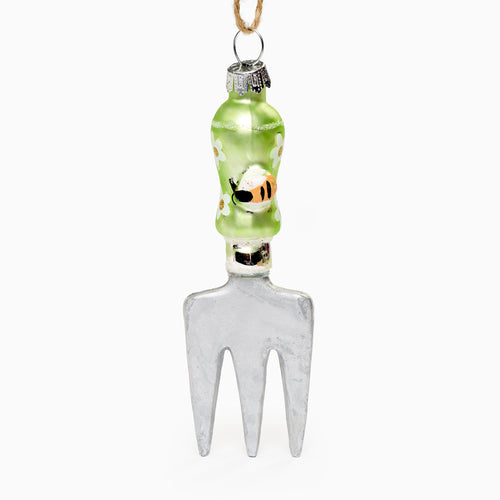 Decorative glass garden tool with a green handle and white head on a white background