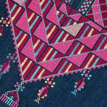 Load image into Gallery viewer, Close-up of a cross-stitched pattern with pink, red, and yellow triangles on a dark blue fabric background.
