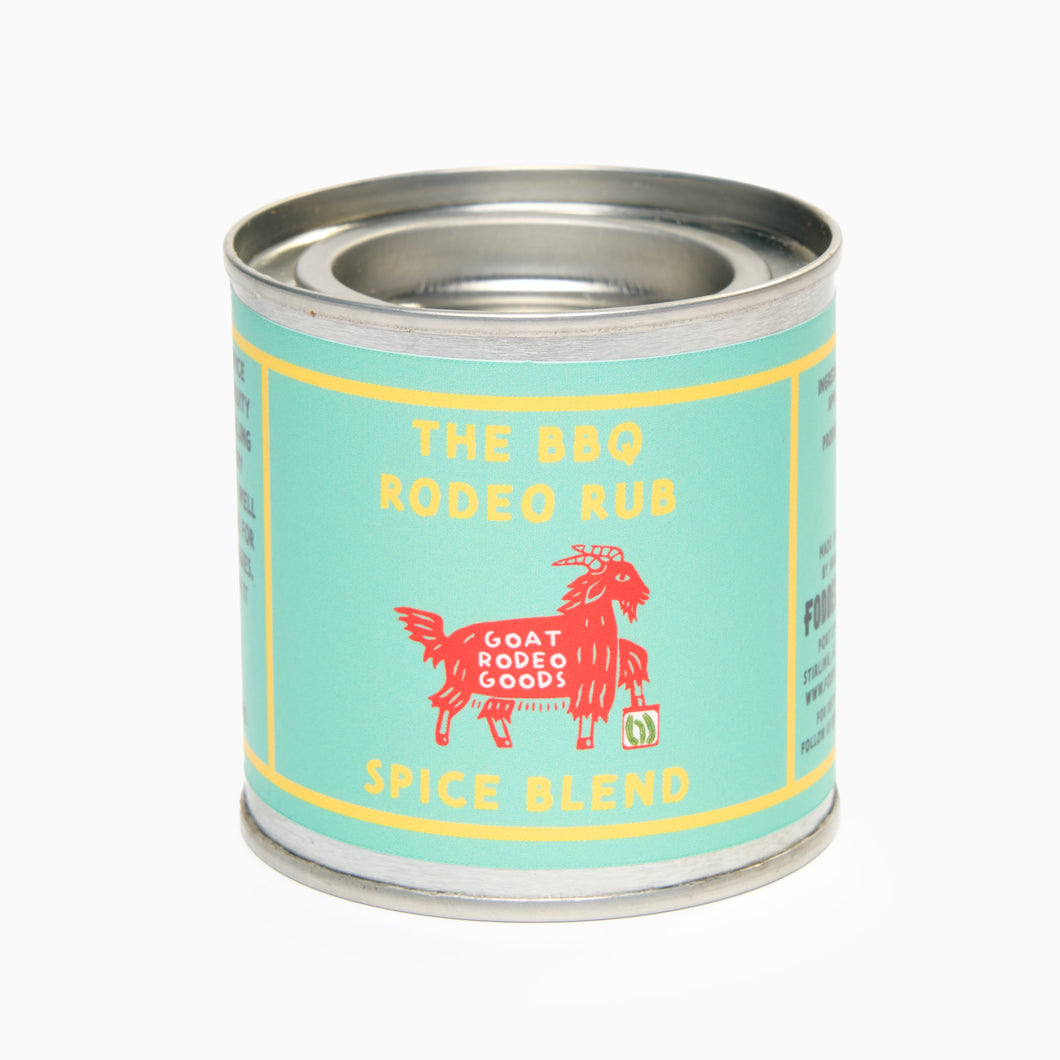 A tin container labeled 'The BBQ Rodeo Rub Spice Blend' by Goat Rodeo Goods, with a graphic of a goat on the label.