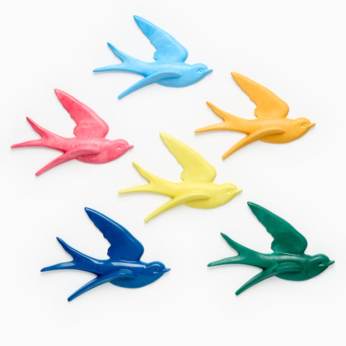 Colourful bird-shaped home decor on a white background. Recycled plastic by Anna Campbell Jones