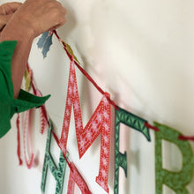 Load image into Gallery viewer, Merry Christmas paper banner letters by Cambridge Imprint being strung together
