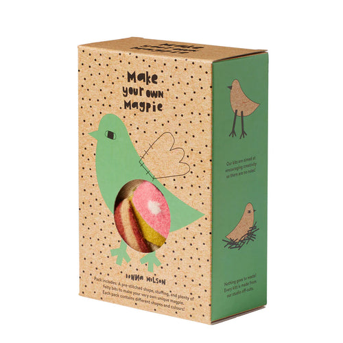 Packaging of 'Make your own Magpie' kit with a window showing a knitted magpie and contents, set against a beige background.