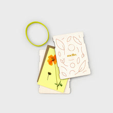 Load image into Gallery viewer, Three greeting cards with floral designs and a green elastic band on a light gray background
