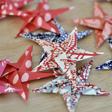 Load image into Gallery viewer, Finished patterned origami stars made with the Cambridge Imprint Garland of Stars kit
