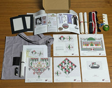 Load image into Gallery viewer, Collection of palestinian tatreez embroidered designs and materials on a wooden surface
