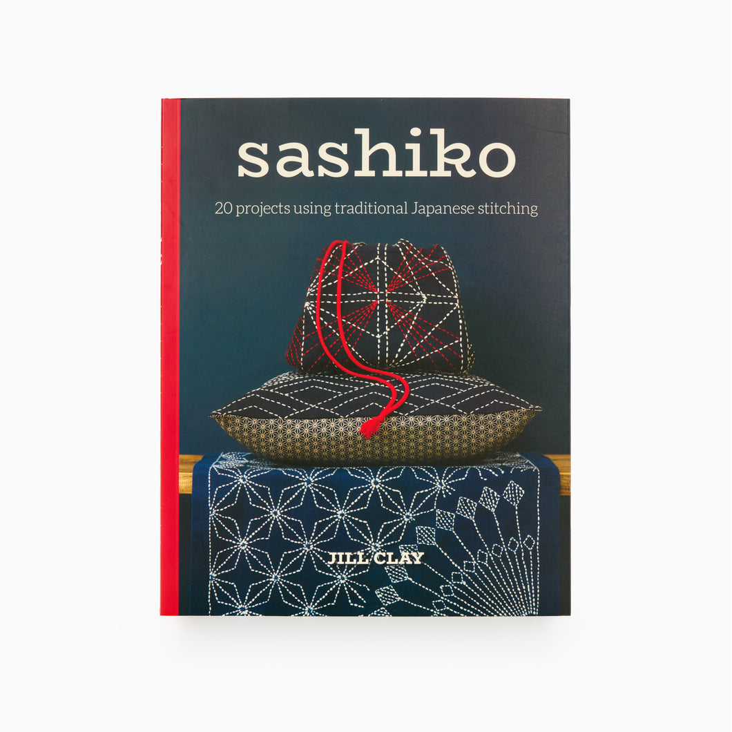 The cover of the book titled 'sashiko: 20 projects using traditional Japanese stitching' by Jill Clay, featuring a photograph of a traditional Japanese basket with Sashiko stitching on it.