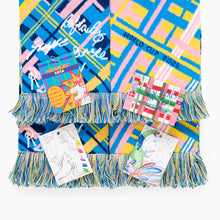 Load image into Gallery viewer, Close-up of Scotland football scarf pattern with blue, yellow and pink design. Tags and tassels are featured.
