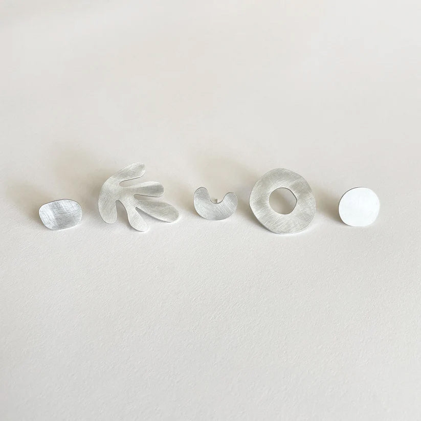 A set of five silver-coloured earrings with assorted shapes displayed on a white background.
