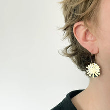 Load image into Gallery viewer, Gold floral earring worn by a person on a plain background
