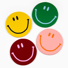 Load image into Gallery viewer, A set of four round leather coasters in different colors, each featuring a smiling face design.

