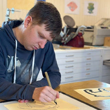 Load image into Gallery viewer, Artist Struan Haswell working on artwork at a studio desk
