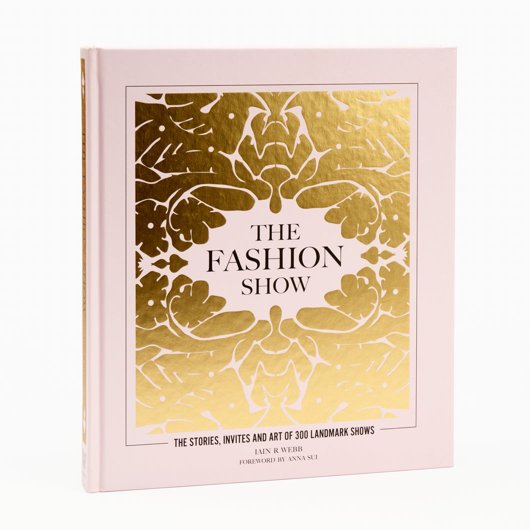 A hardcover book titled 'The Fashion Show' with a gold and white floral pattern on the cover.