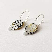 Load image into Gallery viewer, Pair of drop earrings with black, gold, and silver leaf design on a white background
