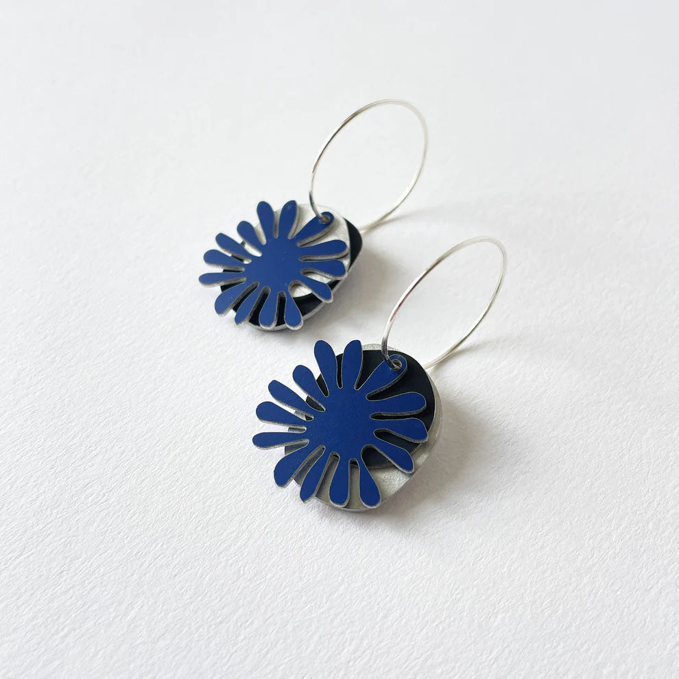 Pair of blue, black and silver floral earrings on a white background
