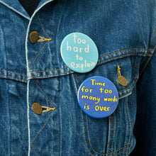 Load image into Gallery viewer, Too Hard to Explain badge by Struan Haswell displayed on a denim jacket alongside other badges
