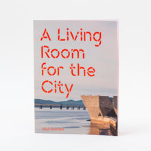 Load image into Gallery viewer, Book cover of 'A Living Room for the City' featuring text and a background image of a building by a body of water.
