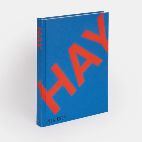 A hardcover book with a blue and red cover, titled 'HAY' by Phaidon.
