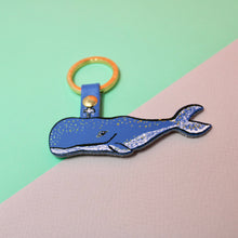 Load image into Gallery viewer, A leather keyring designed in the shape of whale, in blue with metallic foil details.

