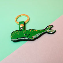 Load image into Gallery viewer, A leather keyring designed in the shape of whale, in green with metallic foil details.
